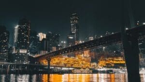 a bridge over water with city lights at night